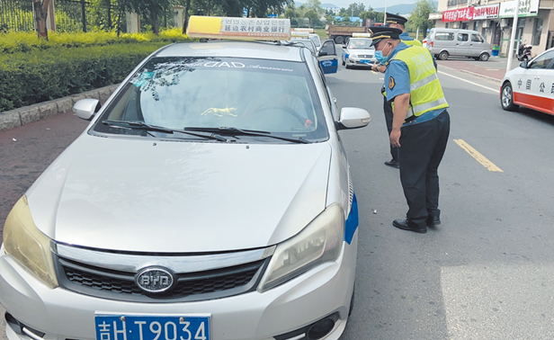 图为执法人员督促出租汽车驾驶员切实做好疫情